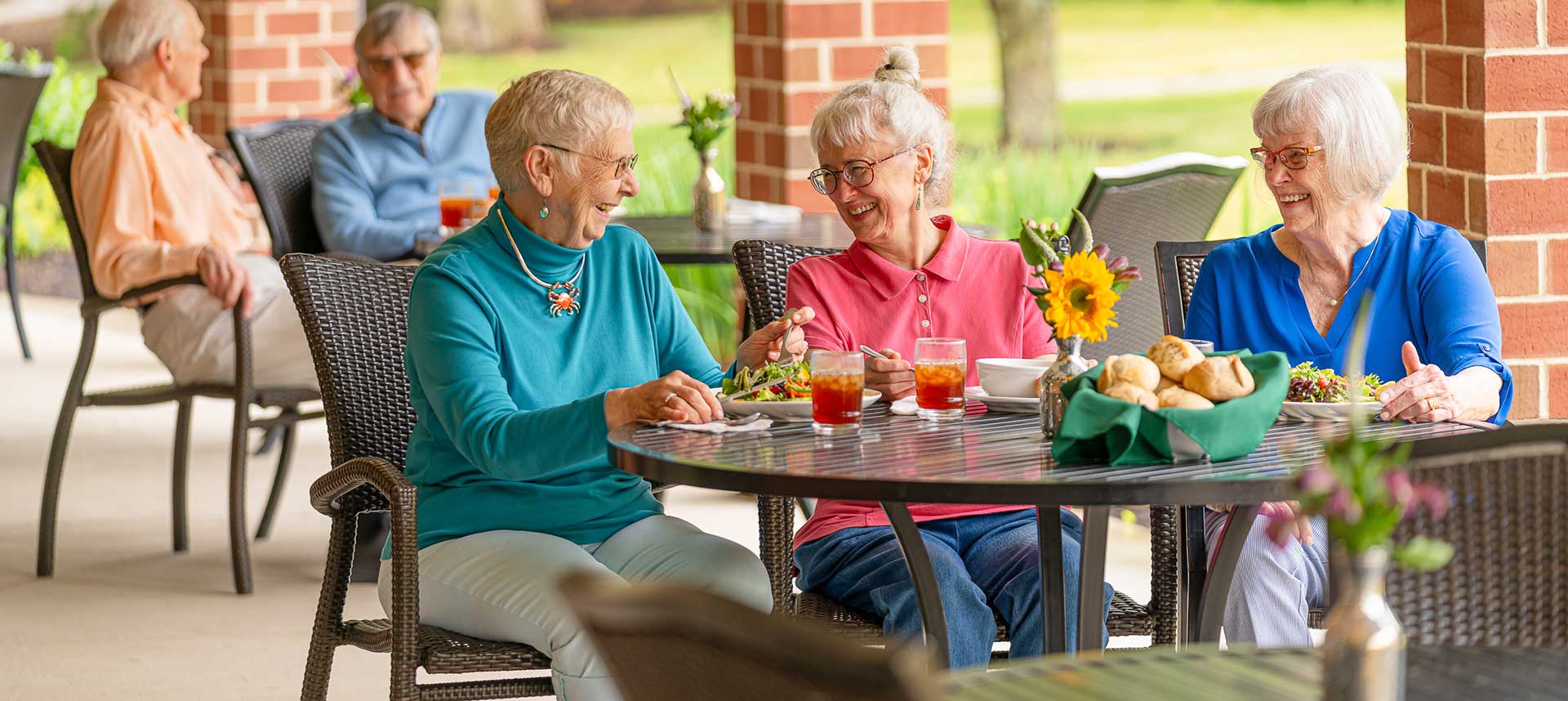 Friends enjoying a meal outside at Foxdale Village