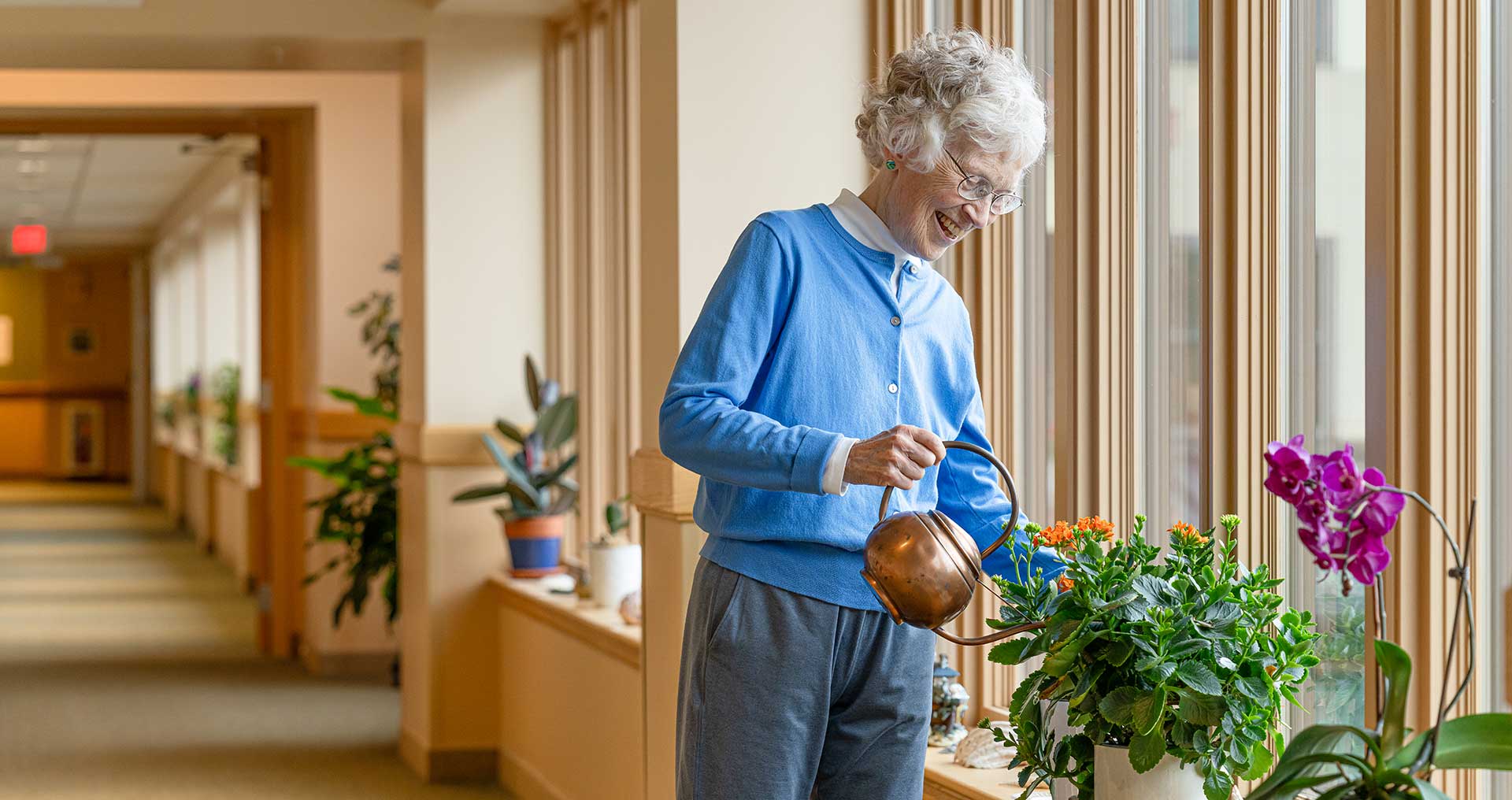 Resident watering the plants at Foxdale Village